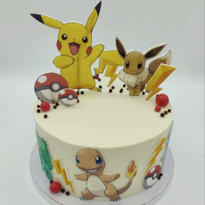 tort Pokemon z figurkami Pikachu i Eevee biała polewa czerwone akcenty