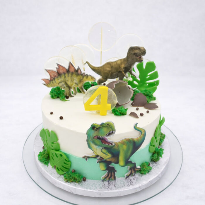 tort dinozaury z kremowym biszkoptem zielone liście figurki dinozaurów żółta cyfra 4