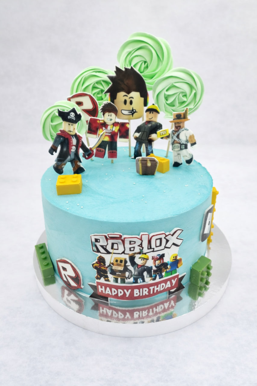 tort Roblox w jasnoniebieskim kremie, dekorowany figurkami postaci i zielonymi lizakami