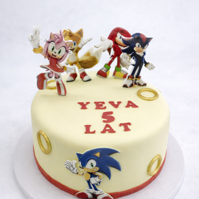 tort Sonic dla dzieci okrągły kremowy z figurkami postaci i złotymi pierścieniami